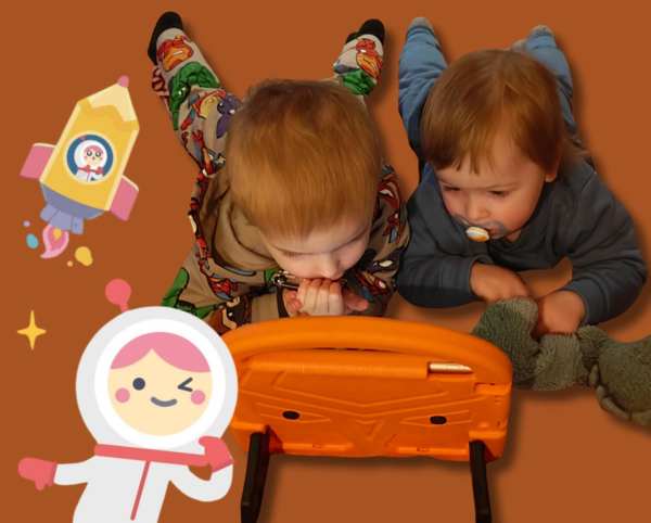 To små barn ligger på gulvet og ser på nettbrett, omgitt av fargerike illustrasjoner fra Hei Albert-appen.